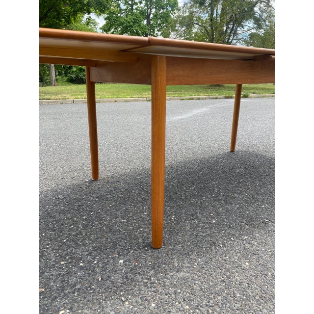Beautiful teak wood table. Minimalist tapered legs, extensions pull out from left and right and sit perfectly level under...