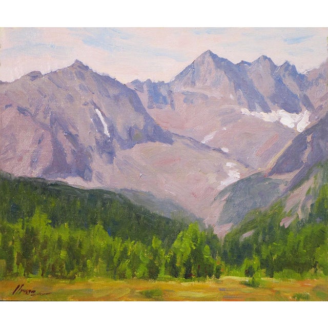The artwork depicts a serene mountain landscape, showcasing rugged peaks under a soft sky. Lush greenery in the foreground...