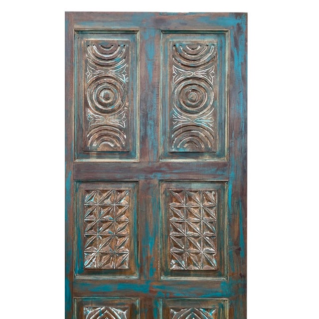 Add bold character and handcrafted charm to your space with this artisan-carved vintage blue barn door. The intricate...