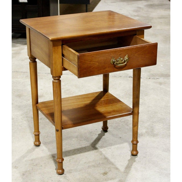 This piece features a classic colonial silhouette with turned legs and a warm, polished wood finish. The single drawer is...