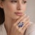 Elegant 18K white gold ring designed in a floral motif, featuring an oval blue sapphire weighing approximately 1.96 carats...