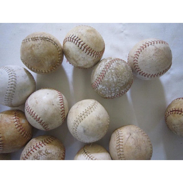 Set of 14 vintage softballs. Age related wear and patina. Each measures 3.63 x 3.63.