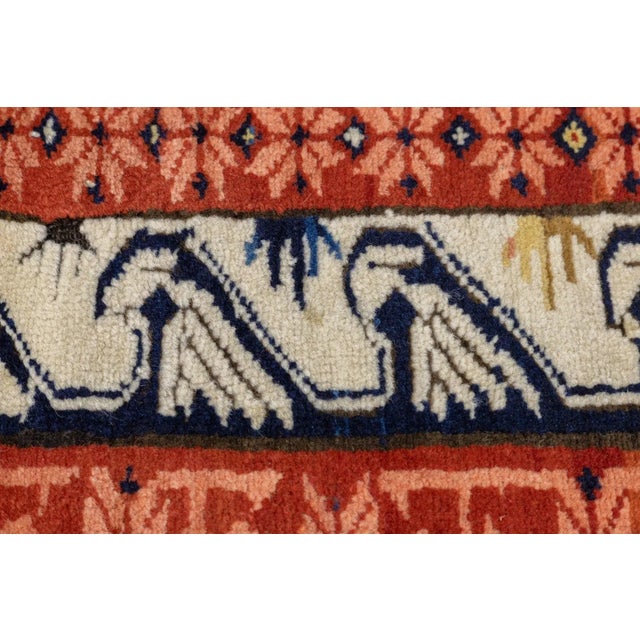The straw field of this east Caucasian village long rug shows a random array of badge-like snowflakes or stars. The main...