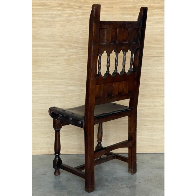 A set of 6 Spanish chairs with leather sling seatsand backs on oak and sycamore frames with hand carved decoration. These...