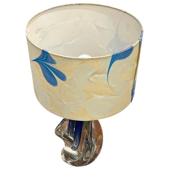 The twisted glass is hand-blown, displaying an irregular design with rounded shapes, all within a clear glass with traces...