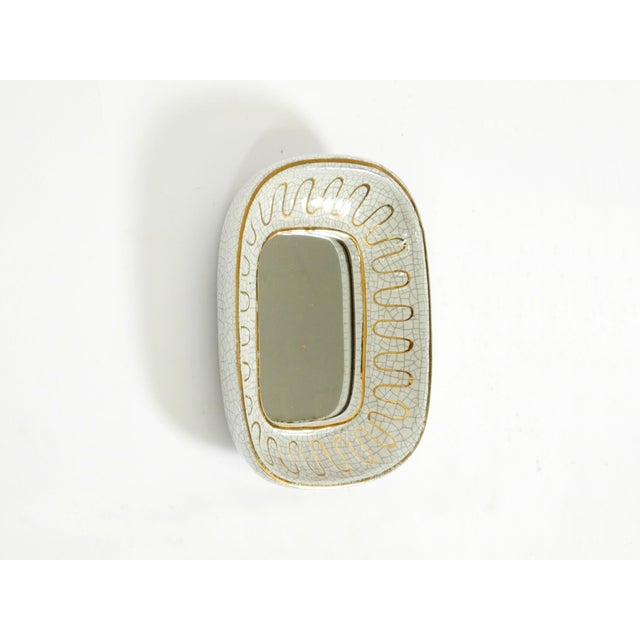 A beautiful, small, original Mid-Century Modern ceramic wall mirror. Manufacturer: "Gmundner Keramik" (Made in Austria)....