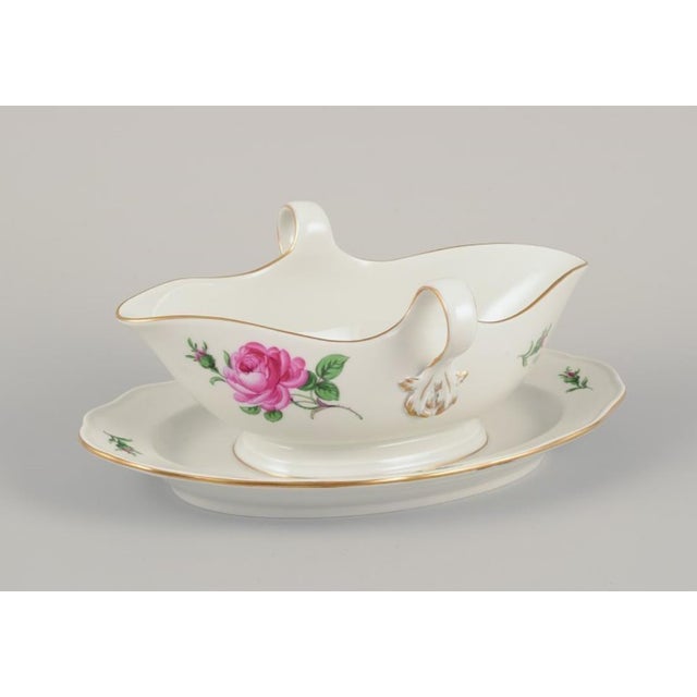 Meissen, Germany. Sauce boat on a stand with a motif of a pink rose. Gold rim. Approximately 1920/30s. In perfect...