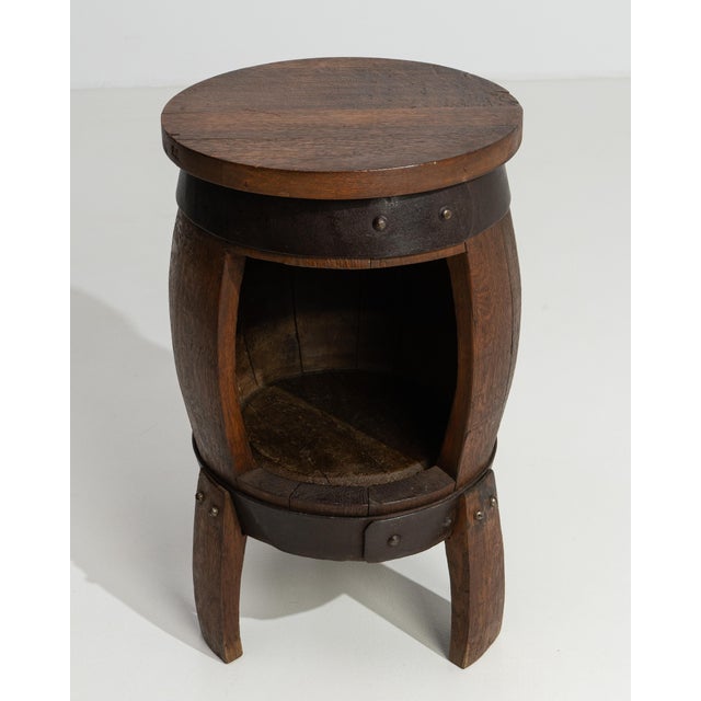 A magnificent example of early twentieth-century French craftsmanship, this oak barrel bar table transforms a storied...