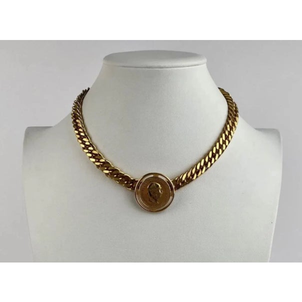 Signed Miriam Haskell gold-tone necklace featuring a wide curb-link gold tone chain and a centrally mounted Austrian coin-...