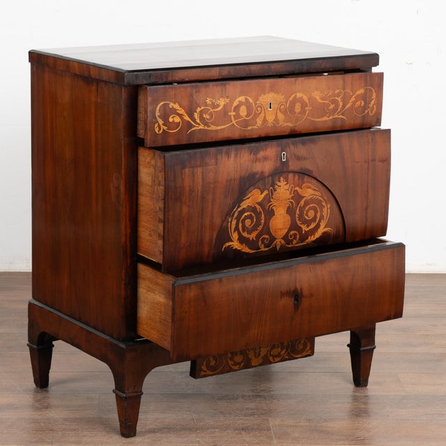 A fine mahogany empire chest of drawers or commode with satinwood inlays. Top drawer reveals storage compartments with...