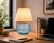 Crafted with high visual clarity, this modern table lamp features a sleek silhouette with a hand-blown glass base paired...