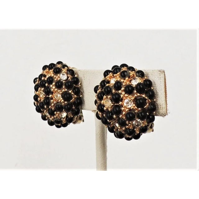 This is part of Chairish’s Costume Jewelry assortment. 1960s goldtone cabochon faux-onyx and clear rhinestone round domed...