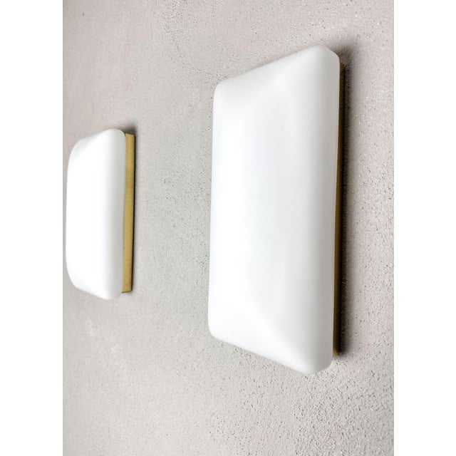 These vintage wall lamps add an elegant touch to any room. with their sleek white glass shades and gold details, they...