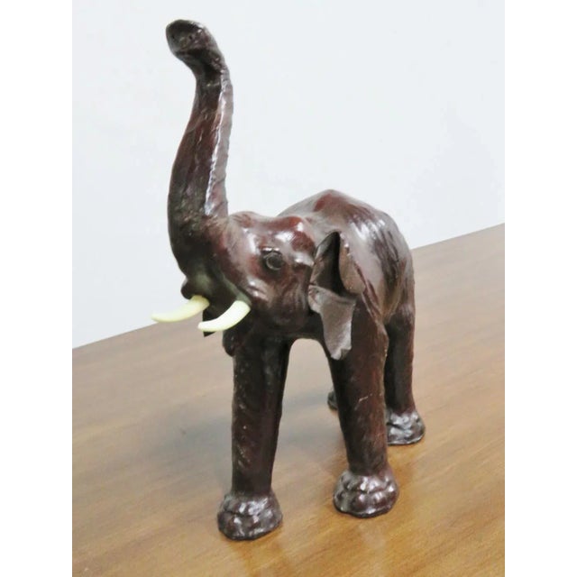 Elephant form statue, leather wrapped with plastic tusk.