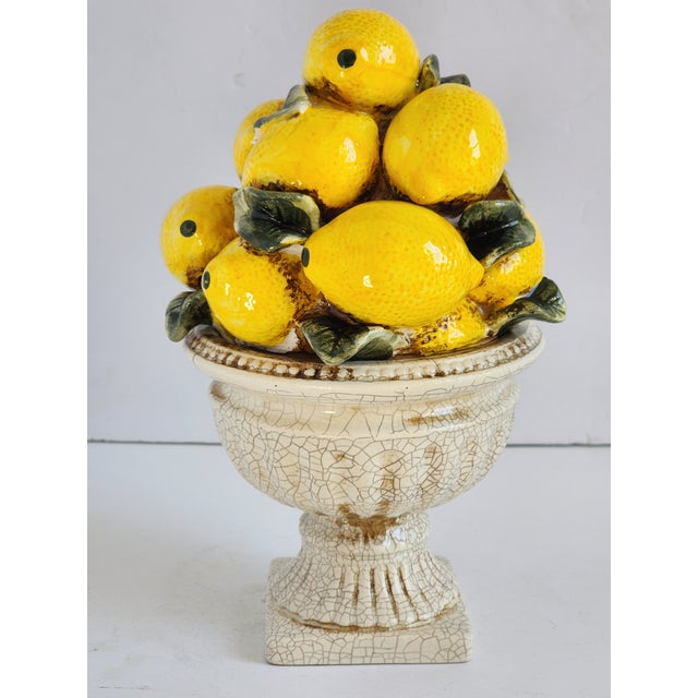 Very pretty lemon ceramic topiary with urn style base in a crackled antique white finish. The sunny yellow lemons will...
