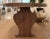 Contemporary organic dining table featuring a rich medium walnut-brown finish with a striking oval top and sculptural...