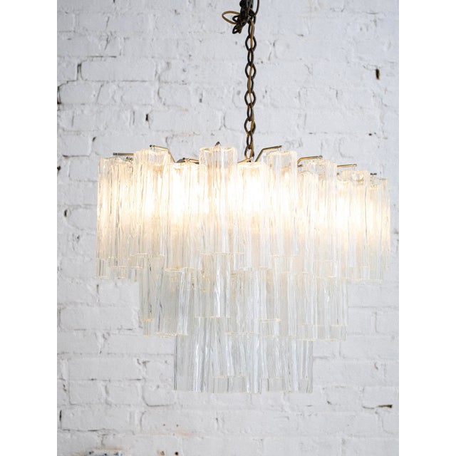 Mid-century Murano-made chandelier. Oval shape with hanging textured "Tronchi" glass tubes. Tronchi glass refers to a...