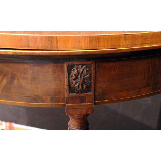 Circa 1790 George III demilune fold-over games table, English. Raised on exquisitely turned, reeded, tapered legs. Carved...