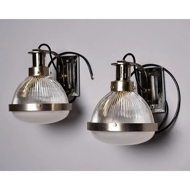 Found in England, this pair of wall lights or sconces date from the 1970s and feature chrome back plates and fittings with...