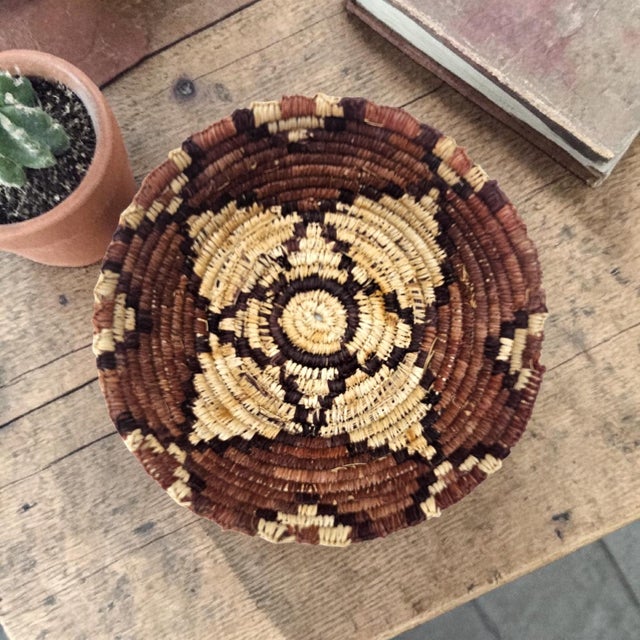 A hand-coiled Southwestern basket bowl constructed in traditional desert fiber techniques using a bundled grass foundation...