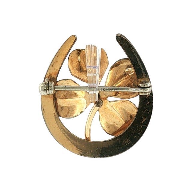 A mid-20th-century Krementz & Co brooch featuring an enameled four-leaf clover and horseshoe design. The brooch is crafted...