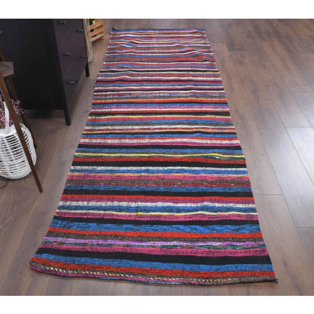Vintage Turkish Hand-Knotted vintage rug is a semi-Vintage kilim runner rug.'70s Eastern region of Turkey's unique rug is...