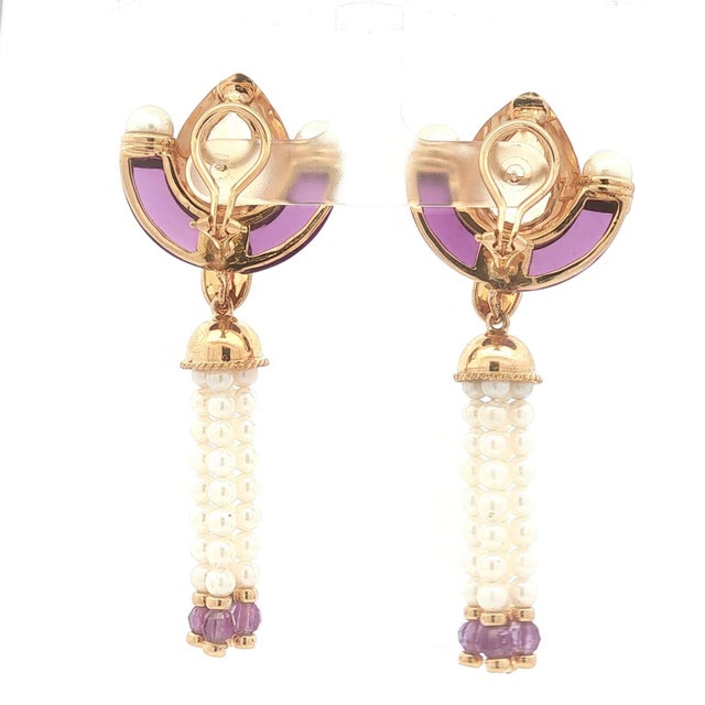 A pair of drop earrings featuring pear-cut orange citrine stones set in 14k gold. Accented with white pearls and purple...