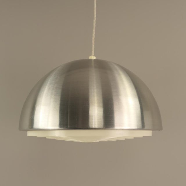 The hemispherical shade is made of brushed aluminium with white plastic diffuser inside. The lamp requires one E27 bulb....