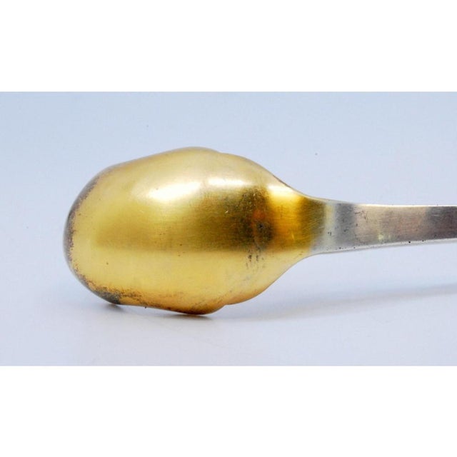 Silver Pickle Spoon with Gold-Colored Shell and Grooves, in Very Good conditions. Designed 1920 to 1949 This piece has an...