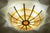 Brutalist-style glass and brass ceiling light, designed with a shell-like form. At the center stands a large red glass...