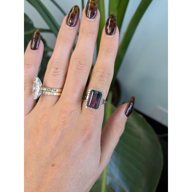 A 6.30-carat bi-color tourmaline emerald-cut sits at the centre of this solid 14K white gold ring, framed by twenty-six...