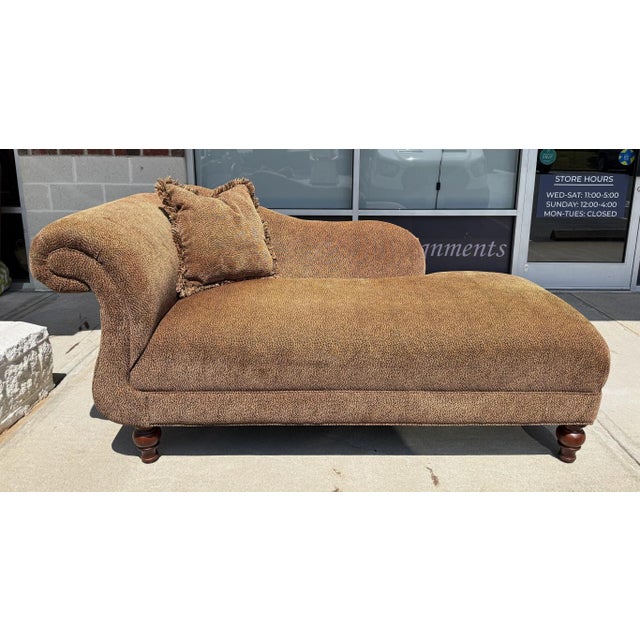 This Leopard Print Upholstered Chaise Lounge features a sweeping rolled arm, generous cushioned seat, and turned wood feet...