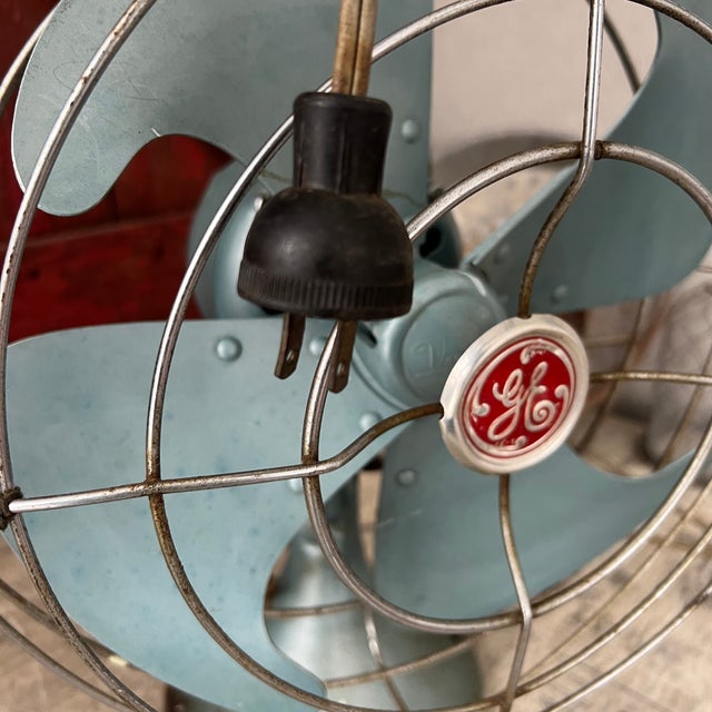 This vintage fan, from General Electric's mid-century era, showcases classic design with its teal metal blades and sturdy...