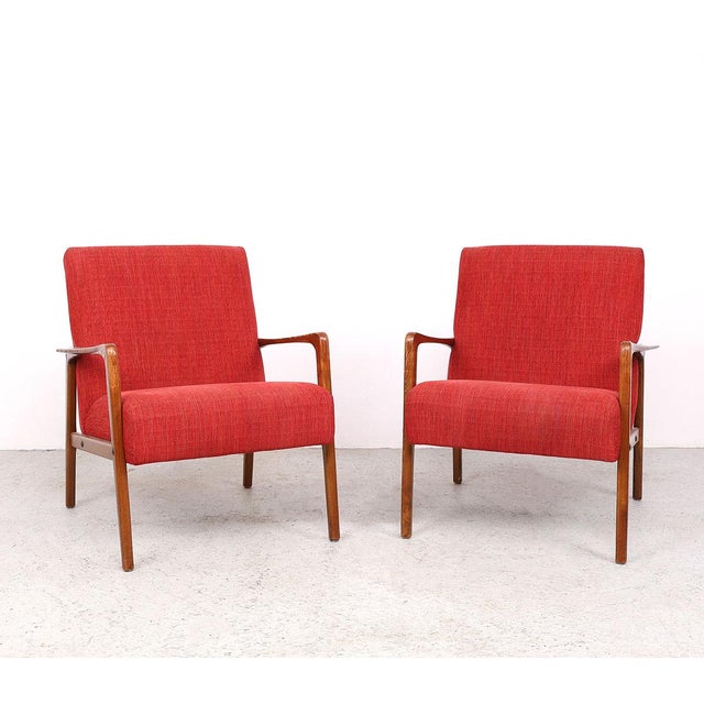 A beautiful set of two Danish design armchairs from the 1950s, featuring an organically shaped wooden frame and warm...