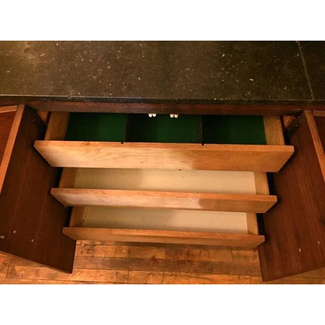 Mid-Century Modern wall-mount cabinet with black marble top and rich rosewood grain. Four storage cabinets with drawers...