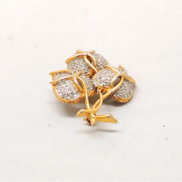 This is part of Chairish’s Costume Jewelry assortment. 1960s goldtone and pavé round clear rhinestones three flower buds...