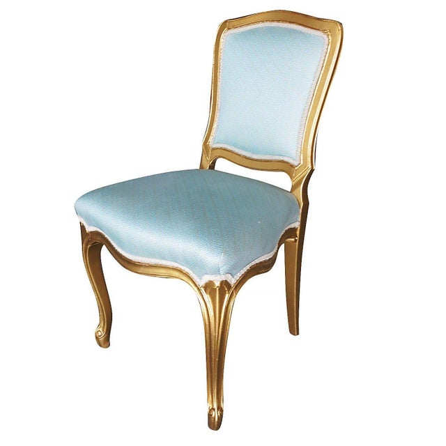 This set of 24 elegant French-inspired side dining chairs features a masterfully hand-carved gilt-wood frame with a...