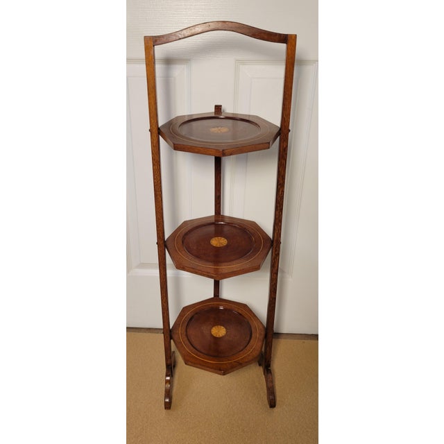 Antique Edwardian inlaid mahogany 3-tier cake stand with shaped top and 3 shaped tiers with satinwood inlaid shells. It...
