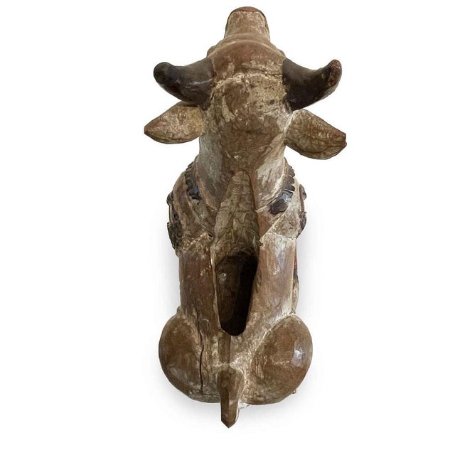 A visibly antique, hand-carved, wooden Nandi cow from India. This wooden sculpture features a wonderful patina due to its...