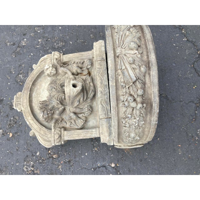 Charming cast stone classical-style table top fountain. The upper backplate features high-relief sculptures of two cherubs...