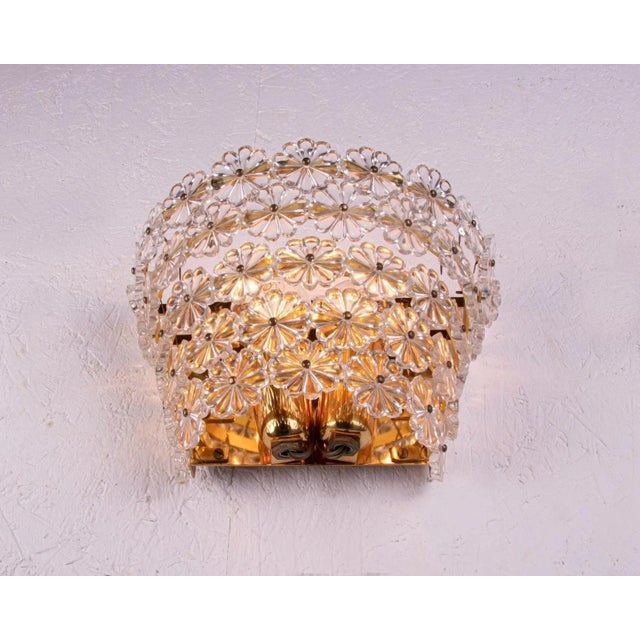 Charming pair of wall sconces with crystal flowers on a brass frame. This kind of lights were manufactured in the 50s by...
