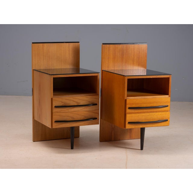 A distinctive pair of vintage Czech bedside tables designed by Mojmir Požar in the 1960s. Each cabinet features a warm...