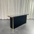Console table in brass, acrylic glass, and black mirror. The base of the console is composed of black acrylic glass panels...