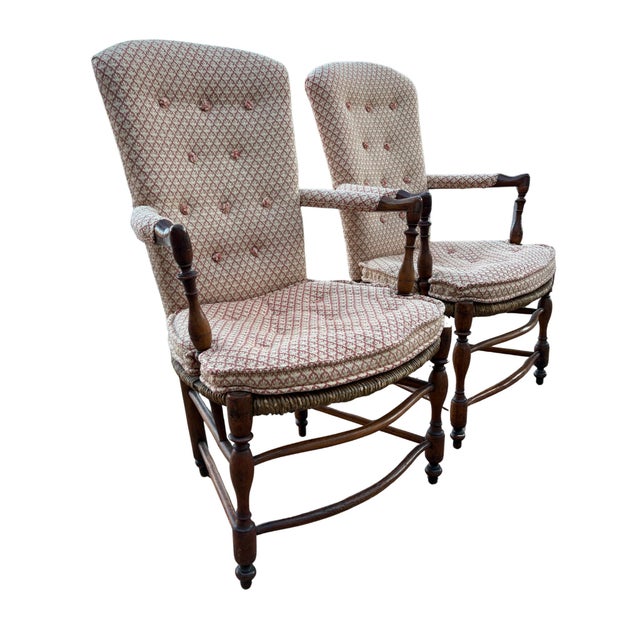 Pair of antique upholstered armchairs featuring classic French Provincial and English country influences. Each chair...