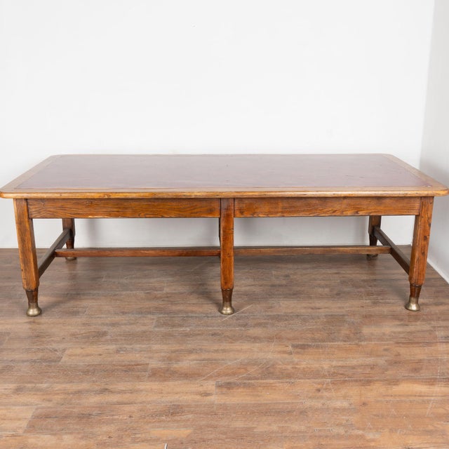 20th century large Danish writing table, crafted in oak with a vintage burgundy red leather top. The desk stands on six...