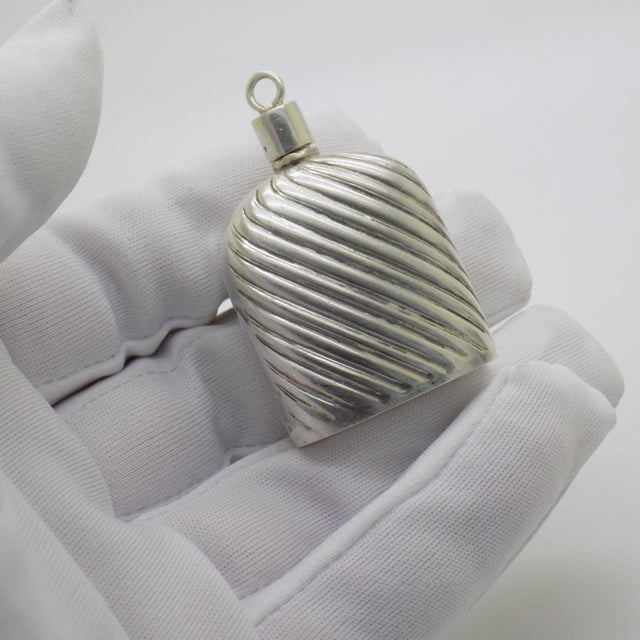 This vintage silver decorative object depicts a detailed miniature perfume bottle, crafted as a vanity table accessory,...