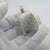 This vintage silver decorative object depicts a detailed miniature perfume bottle, crafted as a vanity table accessory,...