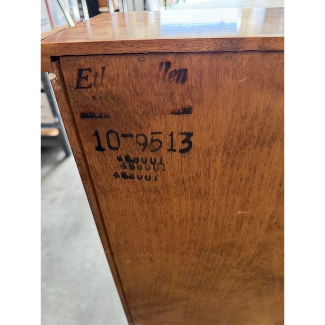 Beautiful vintage Ethan Allen bookcase featuring a warm, honey-toned wood finish, gently curved side panels, and classic...