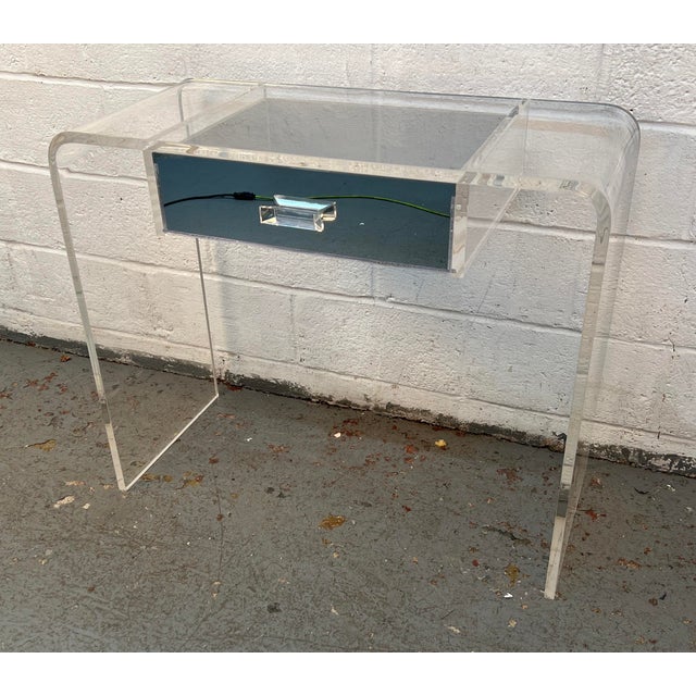 Add a sleek, retro-modern touch to your space with this stunning Lucite waterfall vanity desk. Crafted from thick, high-...