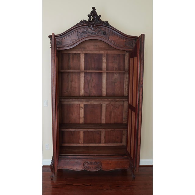 This antique Italian armoire dates to the late 19th century and reflects the refined elegance of the Rococo Revival...